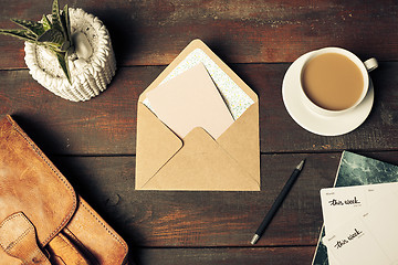 Image showing Opened craft paper envelope , autumn leaves and coffee on wooden table