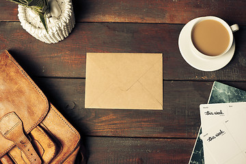 Image showing Opened craft paper envelope , autumn leaves and coffee on wooden table