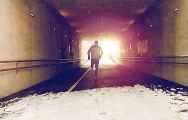 Image showing man running along subway tunnel in winter