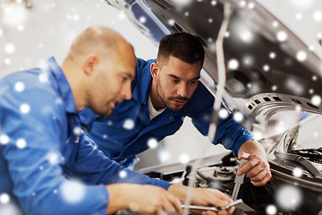 Image showing mechanic men with wrench repairing car at workshop