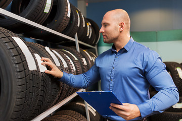 Image showing auto business owner and wheel tires at car service