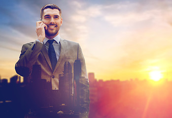 Image showing smiling businessman with smartphone outdoors