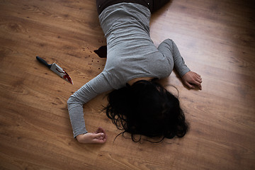 Image showing dead woman body lying on floor at crime scene