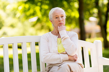 Image showing sad senior woman sitting on bench at summer park