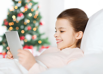 Image showing happy girl in bed with tablet pc at christmas