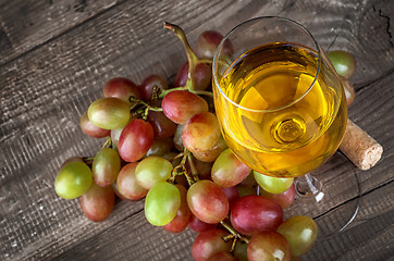 Image showing Glass of white wine with a cluster of grapes