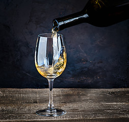 Image showing Pouring white wine from bottle