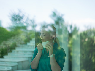 Image showing young woman drinking morning coffee by the window