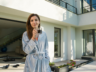 Image showing woman in a bathrobe enjoying morning coffee