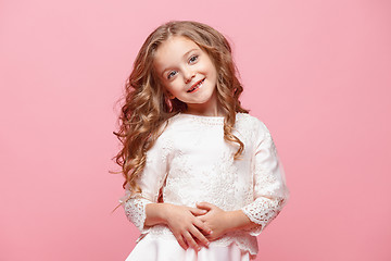 Image showing The beautiful little girl in dress standing and posing over white background