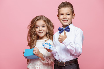 Image showing Boy and girl standing in studio on pink background