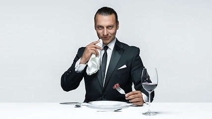 Image showing Bloody Halloween theme: crazy man with a knife, fork and meat