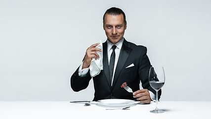 Image showing Bloody Halloween theme: crazy man with a knife, fork and meat