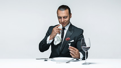 Image showing Bloody Halloween theme: crazy man with a knife, fork and meat