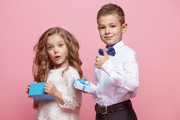 Image showing Boy and girl standing in studio on pink background