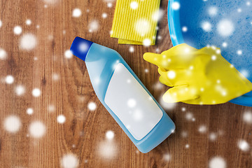 Image showing basin with cleaning stuff on wooden background