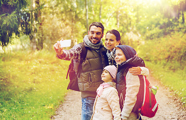 Image showing family with backpacks taking selfie by smartphone