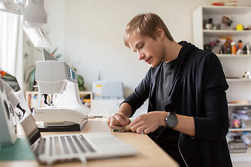 Image showing fashion designer with sewing machine at studio