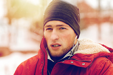 Image showing man with earphones listening to music in winter