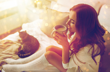 Image showing happy woman with cup of coffee in bed at home