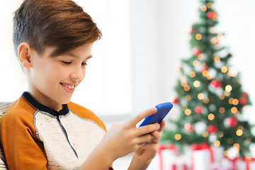 Image showing boy with smartphone at home at christmas