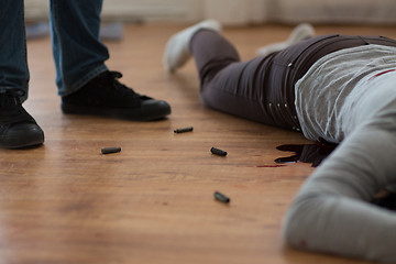 Image showing criminal with dead body and bullets at crime scene