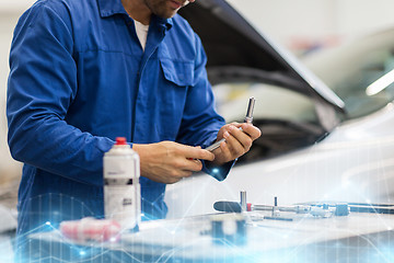 Image showing mechanic man with wrench repairing car at workshop