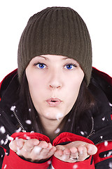 Image showing Woman blowing soft white flakes