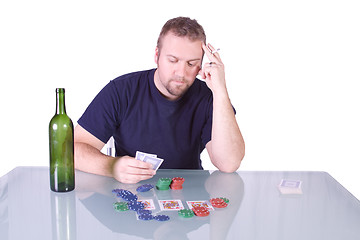 Image showing Man with an Empty Whiskey Bottle on a Poker Table