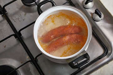 Image showing Boiling sausages on stove