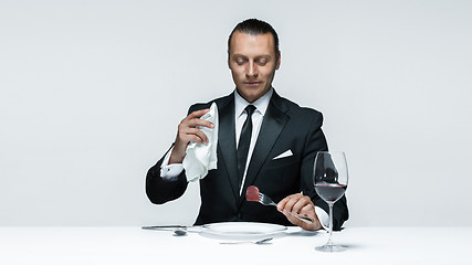 Image showing Bloody Halloween theme: crazy man with a knife, fork and meat