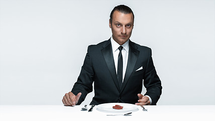 Image showing Bloody Halloween theme: crazy man with a knife, fork and meat