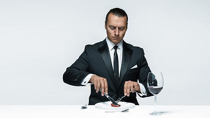 Image showing Bloody Halloween theme: crazy man with a knife, fork and meat