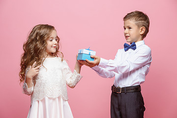 Image showing Boy and girl standing in studio on pink background