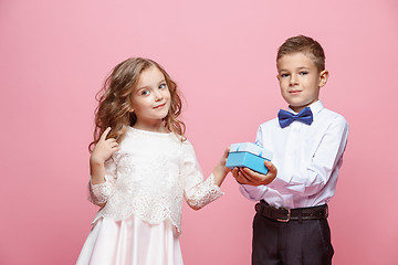 Image showing Boy and girl standing in studio on pink background