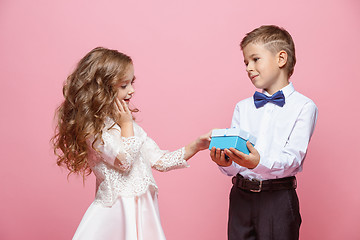 Image showing Boy and girl standing in studio on pink background