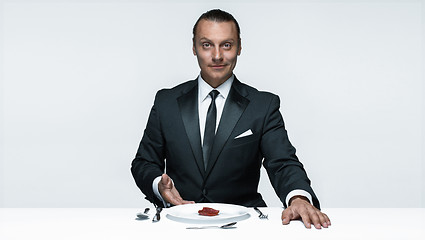 Image showing Bloody Halloween theme: crazy man with a knife, fork and meat