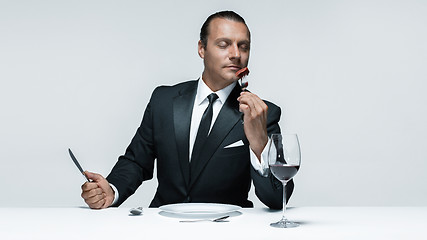 Image showing Bloody Halloween theme: crazy man with a knife, fork and meat