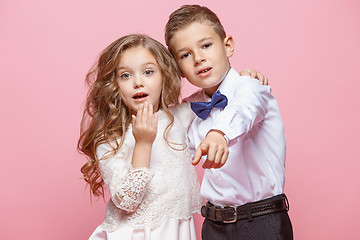 Image showing Boy and girl standing in studio on pink background