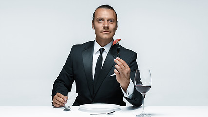 Image showing Bloody Halloween theme: crazy man with a knife, fork and meat