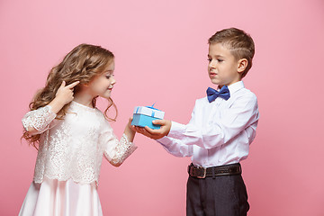 Image showing Boy and girl standing in studio on pink background