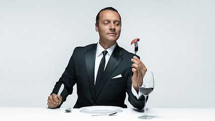 Image showing Bloody Halloween theme: crazy man with a knife, fork and meat