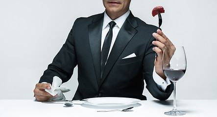 Image showing Bloody Halloween theme: crazy man with a knife, fork and meat