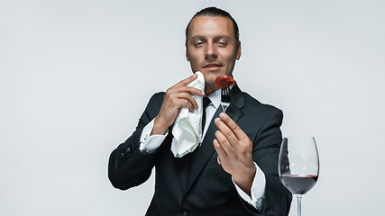 Image showing Bloody Halloween theme: crazy man with a knife, fork and meat