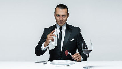 Image showing Bloody Halloween theme: crazy man with a knife, fork and meat