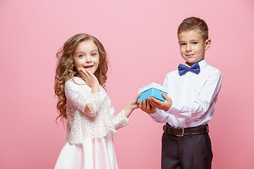 Image showing Boy and girl standing in studio on pink background