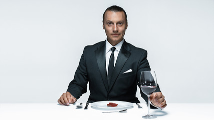 Image showing Bloody Halloween theme: crazy man with a knife, fork and meat