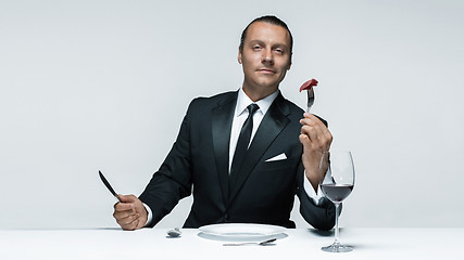 Image showing Bloody Halloween theme: crazy man with a knife, fork and meat