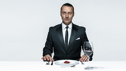 Image showing Bloody Halloween theme: crazy man with a knife, fork and meat