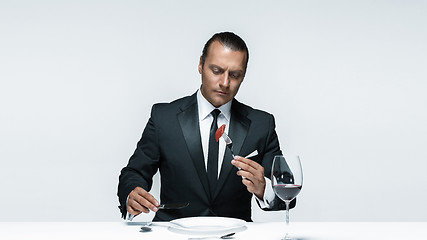 Image showing Bloody Halloween theme: crazy man with a knife, fork and meat